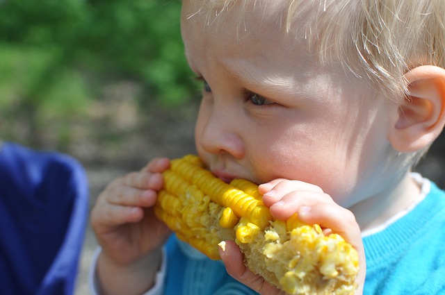 chłopak je kukurydzę